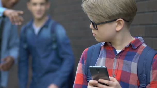 Studenti multietnhic, kteří se vysmívám mladšímu chlapci v problémech s šikanou — Stock video