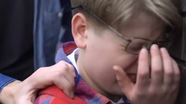 Жорстокі багатоетнічні хлопці атакують хлопчика в розбитих окулярах на шкільному подвір'ї — стокове відео