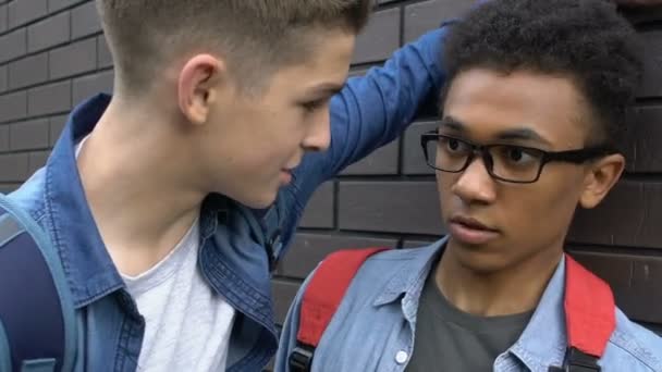 Agresivní běloch tlačí kapesné a zastrašuje černošského teenagera — Stock video