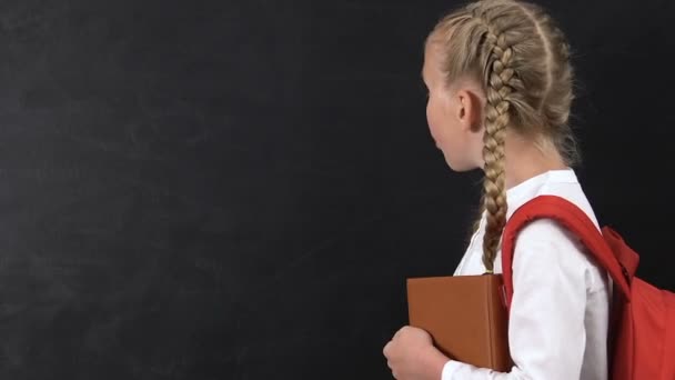 Ενθουσιασμένος κορίτσι που οδηγεί το δάχτυλο στον μαυροπίνακα, μαθήματα σχολείου, πρότυπο για το κείμενο — Αρχείο Βίντεο