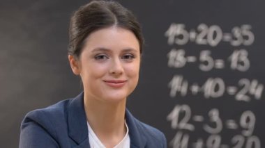 Öğretmen ve küçük okul çocuğu tahta arka plan karşı kameraya gülümseyen