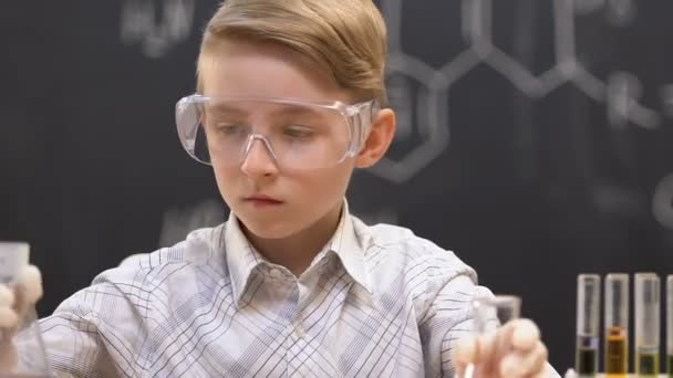 Kleine wetenschapper die kolven vergelijkt met blauwe en rode vloeistoffen, experiment resultaat — Stockvideo