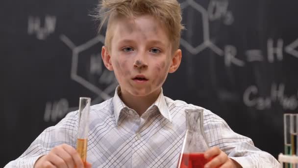 Menino sujo olhando para a câmera na aula de química, resultados de experimentos defeituosos — Vídeo de Stock