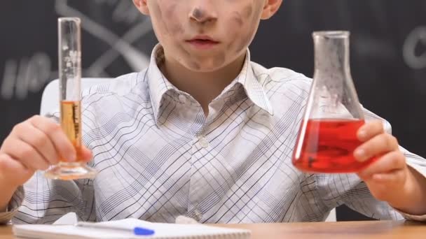 Confused schoolboy shrugging shoulders, dirty face after chemical experiment — Stock Video