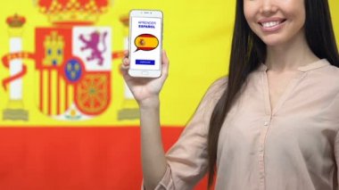 Kadın elinde akıllı telefon ekranında İspanyolca dil uygulaması öğrenin, online eğitim