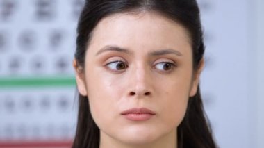 Korkmuş kadın hastanın gözlerine phoropter koyan oftalmolog, görme testi