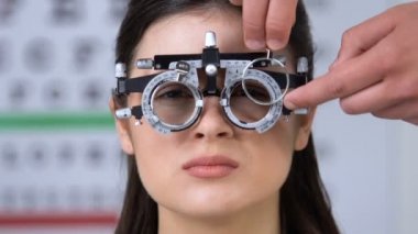 Doktor kadın hasta gözleri, kötü görme giyen phoropter lens koyarak