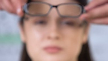 Doktor, gülümseyen kadın yüzüne gözlük takma, görme düzeltme, sağlık