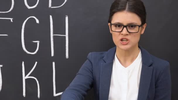 Sinir kadın öğretmen tahta arka plan karşı megafon bağırıyor — Stok video