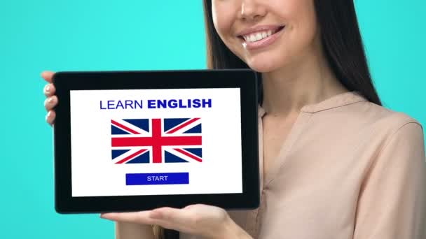 Улыбающаяся женщина держит в руках табличку с тестом на знание английского языка, учебное приложение — стоковое видео