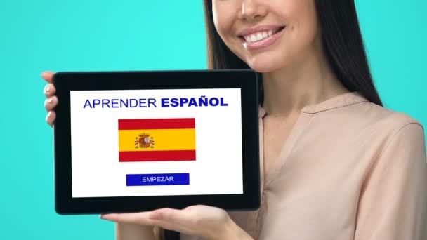 Zadowolony kobieta trzyma tablet z nauki języka hiszpańskiego aplikacji, program edukacyjny — Wideo stockowe