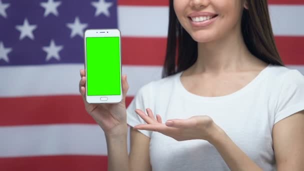 Smartphone with green screen in female hands, USA flag background, application — Stock Video