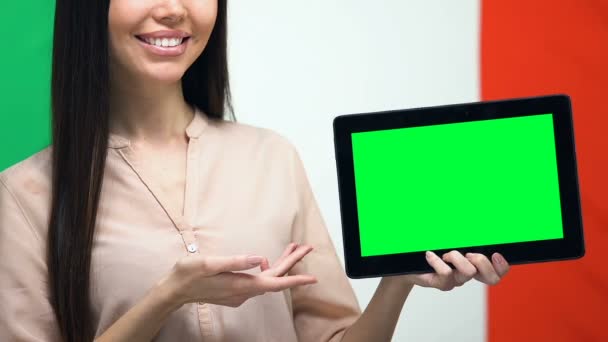 Tableta de pantalla verde en la mano femenina contra la bandera italiana, aplicación de viaje, emigrante — Vídeo de stock