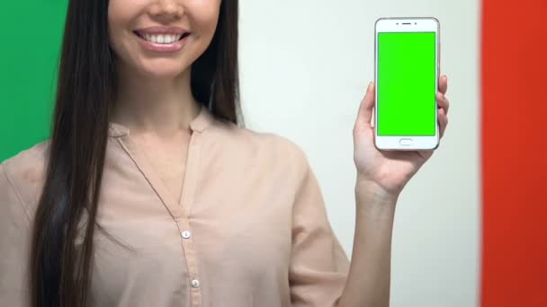 Celular con pantalla verde en mano femenina contra bandera italiana, aplicación de traductor — Vídeos de Stock