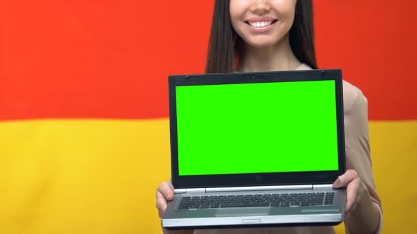 Ordenador portátil con pantalla verde en manos de las mujeres, fondo de la bandera alemana, aplicación de viaje — Vídeo de stock