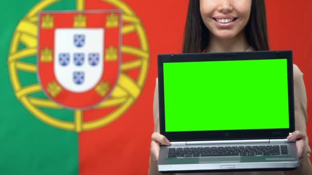 여성의 손에 녹색 화면, 포르투갈 국기 배경 여행 응용 프로그램과 노트북 — 비디오