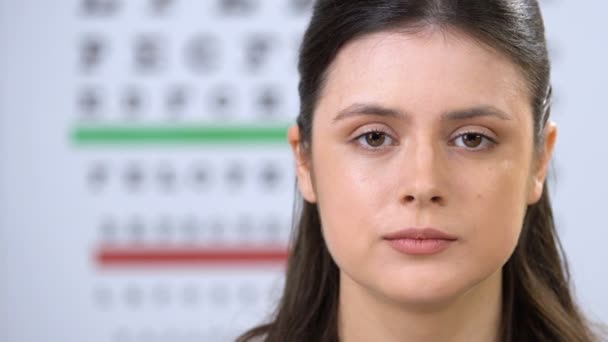 Glimlachend vrouwtje met contactlens bij de camera, patiënt aanbeveling, keuze — Stockvideo