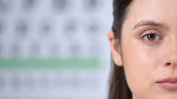 Жінка вивчає здоров'я очей за допомогою збільшувального скла, шаблон для тексту — стокове відео