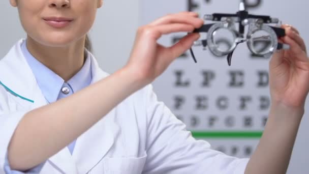 Офтальмолог показывает фотоптер, прибор для проверки зрения, медицинское оборудование — стоковое видео
