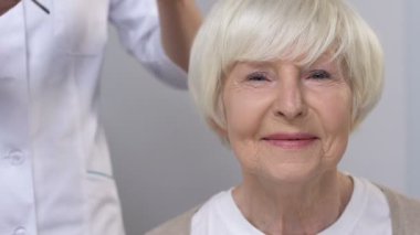 Görme sorunları olan yaşlı yaşlı kadına gözlük veren doktor, sağlık