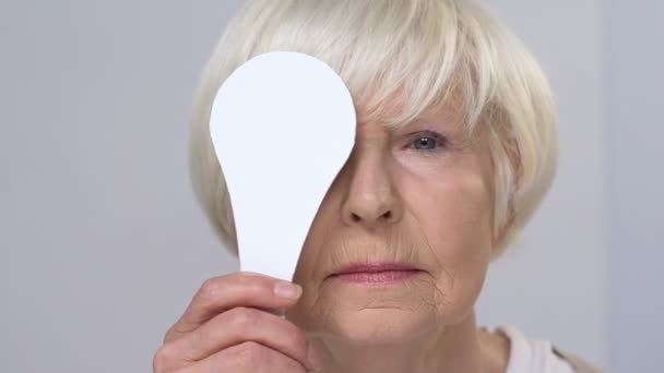 Usmívající se starší samice mžouravá na zkoušku vidění, zavíhající jedno oko, zdraví — Stock video