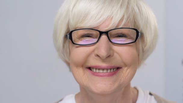 Oudere dame in eye glasses vrolijk glimlachend op camera, gezondheidszorg, examen — Stockvideo