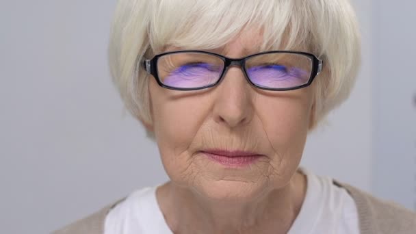 通过眼镜、健康问题、诊所致心的老年妇女聚焦视力 — 图库视频影像