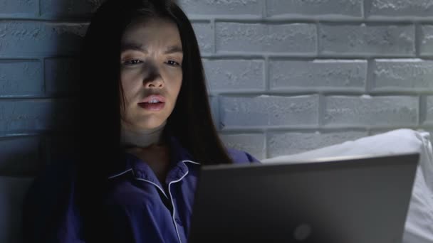 Уставшая женщина с ноутбуком с трудом работает над проектом ночью, сроки просрочены — стоковое видео