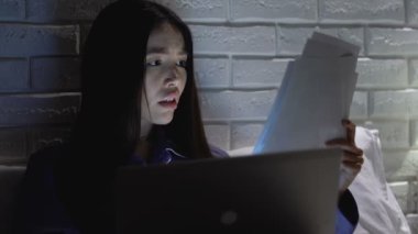 Sinir kadın yöneticisi belgeleri kontrol ve geceleri dizüstü bilgisayar üzerinde çalışıyor