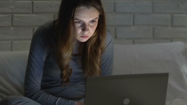 Tired girl staring closely at laptop monitor in bed, bad posture, back health — Stock Video