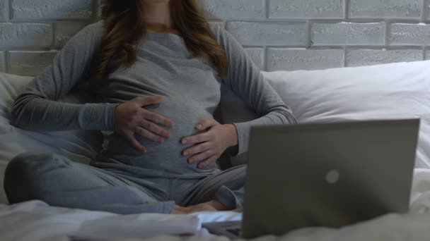 Mujer embarazada poniendo auriculares en la barriga, el desarrollo del bebé, la maternidad — Vídeos de Stock