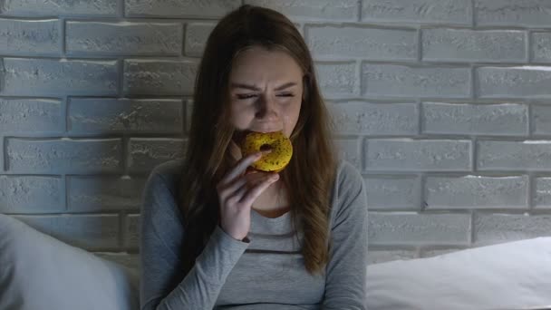 Crying woman eating donut at night, bulimia health problems, mental disorder — Stock Video