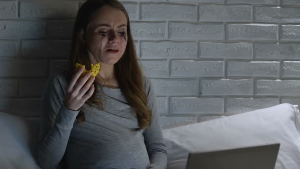 Diep huilen zwangere vrouw eten donut voor laptop 's nachts, problemen — Stockvideo