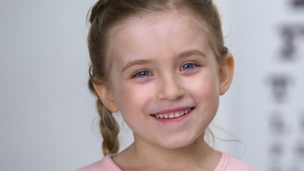 Vidám kislány mosolyogva a kamerán, gyermekkori izgalom, boldogság koncepció — Stock videók