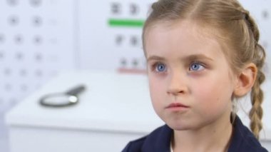 Optik deneme çerçevesi kullanarak kız görme inceleyen optometrist, görme kontrol