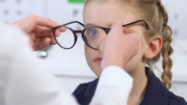 Mutlu kız doktor tarafından reçete gözlük koyarak, aynaya bakarak, sağlık