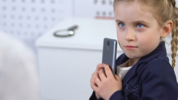 Ophthalmologist trying to take smartphone from girl hands, gadget addiction — Stock Video