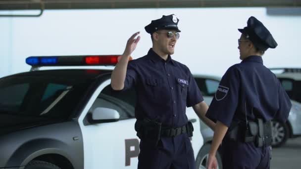 Veselý policista a policistka, kteří si navzájem dávají pět, spoluhráči — Stock video