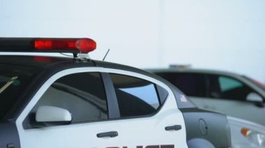 Kendinden emin polis arabadan iniyor, güneş gözlüğü takıyor ve olay yerine gidiyor.