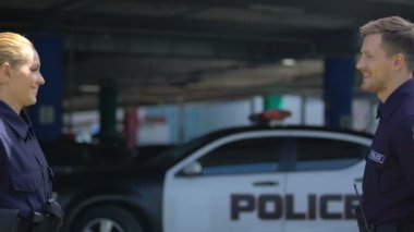 Polis arkadaşları birbirlerini selamlıyor ve devriye arabasına gidiyor, görev lerini taşımaya hazır.