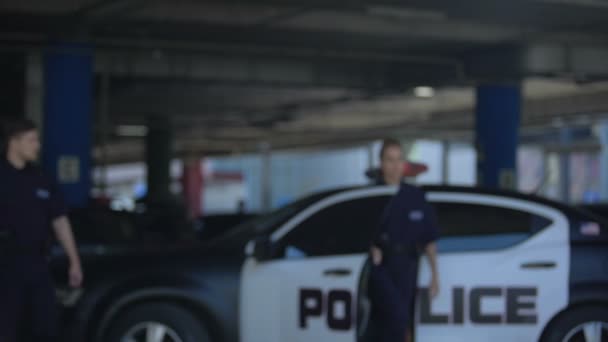 Két rendőrségi tisztviselők kiszállok a kocsiból, és megy a baleset helye, veszély — Stock videók