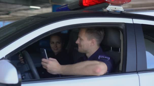 Policía profesional blogueando sobre la vida de los agentes de policía, usando el teléfono sentado en el coche — Vídeos de Stock