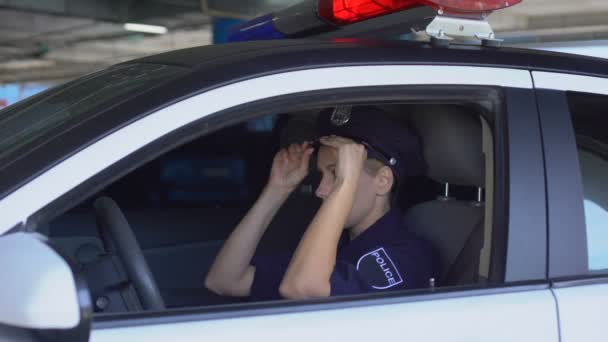 Joven mujer policía que monta sombrero en el coche, listo para proteger a las personas y la propiedad — Vídeo de stock