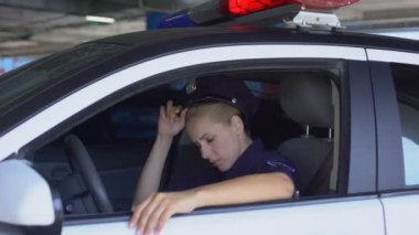 Yorgun polis kadın şapka çıkararak, ekip arabada oturan, yorgun alt iş