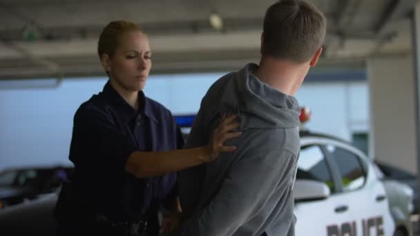 Politie vrouw gevangen gevaarlijke Hooligan, zetten hem in de auto, misdaadpreventie — Stockvideo