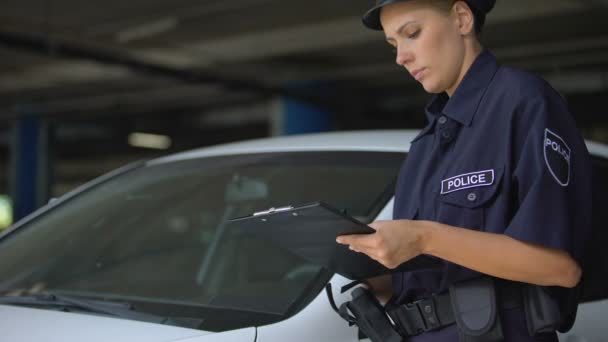 Policía mujer escribiendo multa de tráfico y poniéndose parabrisas, violación de estacionamiento — Vídeo de stock