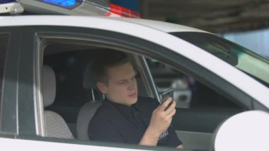 Devriye arabasında gülen polis akıllı telefon, sosyal ağ bağımlılığı sohbet
