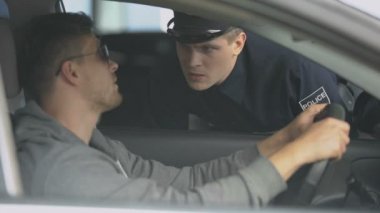 Hız sınırını aştıktan sonra erkek sürücü belgesi kontrol ciddi polis