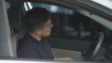 Devriye arabasında oturan ve güneş gözlüğü takan kendine güvenen polis, işe hazır