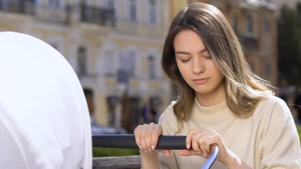 Fáradt fiatal anya lengő Baby babakocsi, alszik parkban, a pihenés hiánya — Stock videók